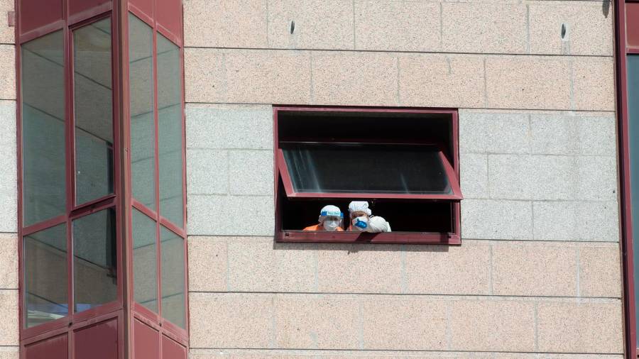 Imagen de archivo de dos trabajadores protegidos que se asoman por una de las ventanas de la residencia de mayores DomusVi de Outeiro de Rei en Lugo. FOTO: Carlos Castro