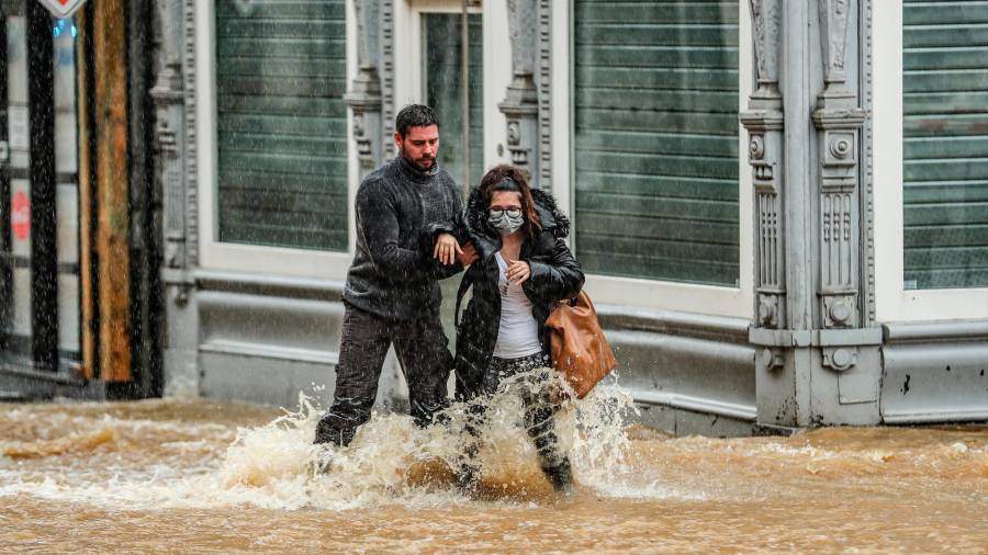 Bélgica, Spa: Un hombre ayuda a una mujer a cruzar una calle inundada tras las copiosas lluvias / Foto: Bruno Fahy/BELGA/dpa 14/07/2021