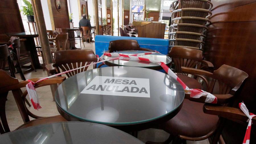 hostelería. Una mesa anulada en el interior de un bar de Vigo, que subió a nivel medio. Foto: Europa Press