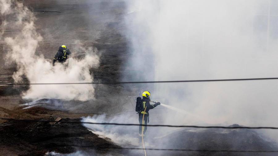 Dos bomberos trabajan en la extinción del fuego de la antigua fábrica de Pontesa