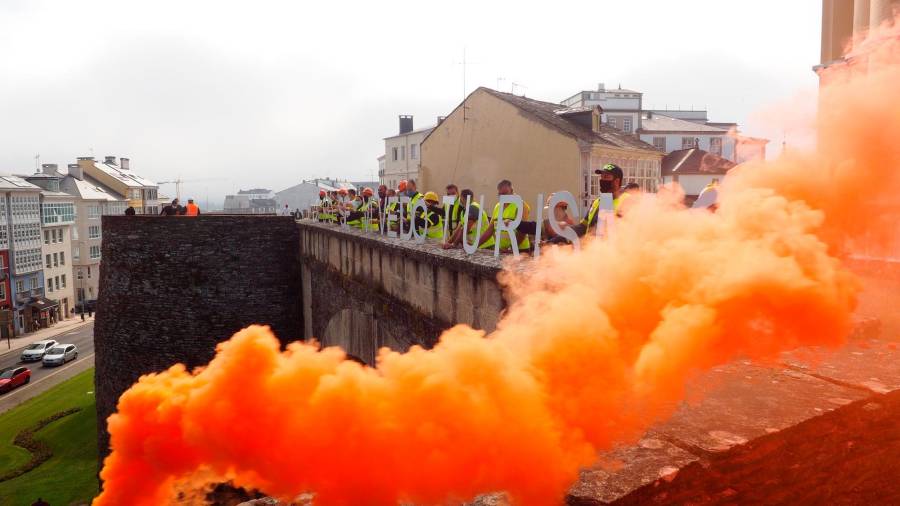 EN NARANJA. Movilización este viernes de operarios de Alcoa, en la Muralla de Lugo. Foto: Eliseo Trigo / EFE