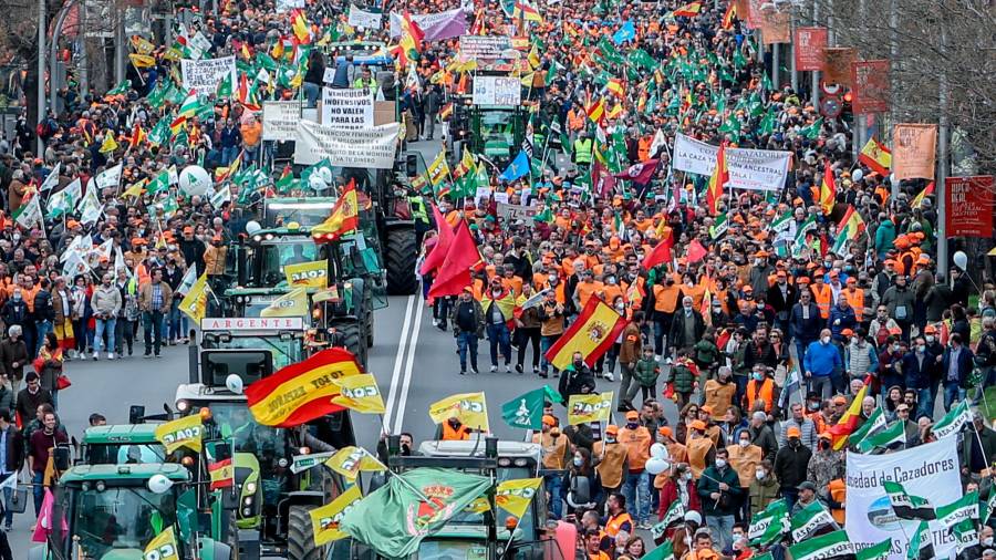 Varios tractores y manifestantes con pancartas, bandera, durante la marcha ‘20M’, a 20 de marzo de 2022, en Madrid (España). Los organizadores de esta convocatoria, denominada como ‘20M’, son Asaja, COAG, UPA, Real Federación Española de Caza (RFEC), Oficina Nacional de la Caza (ONC), Alianza Rural, Unión de Criadores del Toro de Lidia (UCTL), Federación Nacional de Comunidades de Regantes de España (Fenacore) y Cooperativas Agro-alimentarias. Esta multitudinaria marcha reivindica un futuro mejor para el mundo rural y las actividades que lo sustentan. Más de 1500 autobuses con manifestantes han venido de toda España. // Ricardo Rubio / Europa Press 20/03/2022
