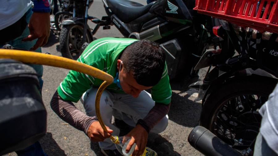 falta. Un hombre llena una botella con gasolina ante su escasez por los bloqueos (Cartago). Foto: S.Osorio 