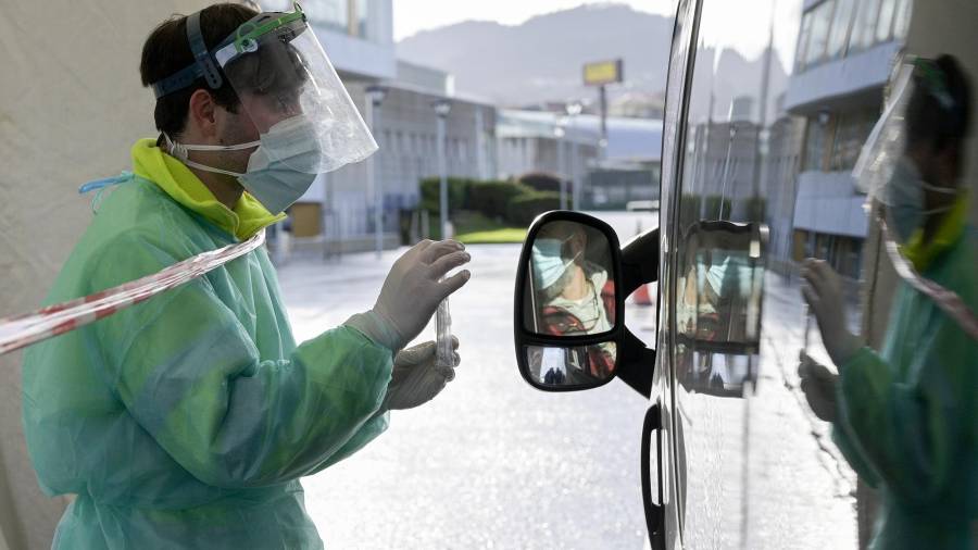 Una persona recoge su test de saliva desde el coche en la Avenida de Arsenio Iglesias en Arteixo, A Coruña, Galicia (España), ayer domingo. M. DYLAN/EUROPA PRESS