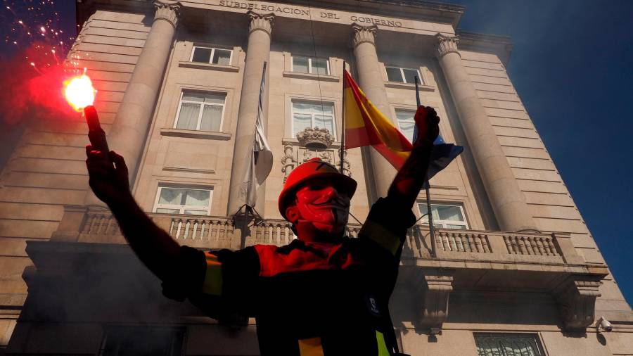 Un manifestante con una bengala delante de la subdelegación del Gobierno, durante la protesta convocada por los trabajadores de Alcoa San Cibrao por la viabilidad de la única fábrica de aluminio primario que queda en España bajo el lema 'A loita continúa'. Foto: EFE/Eliseo Trigo