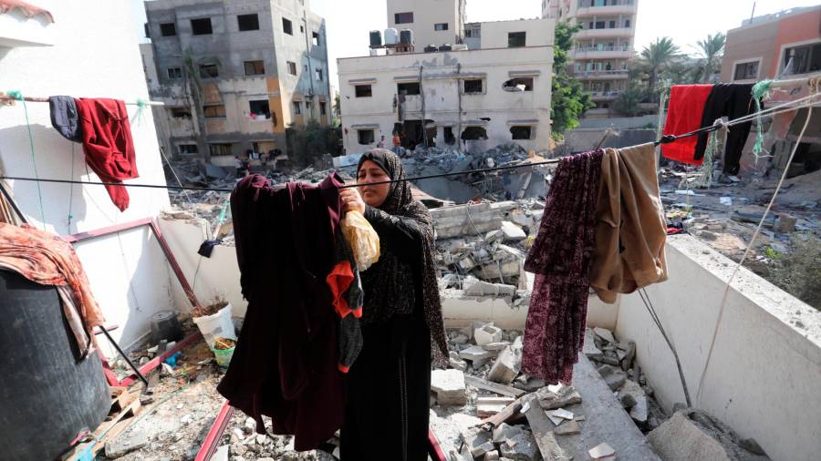 Una mujer cuelga la ropa sobre los escombros de un edificio en Gaza. Foto: Ashraf Amra/E.P.