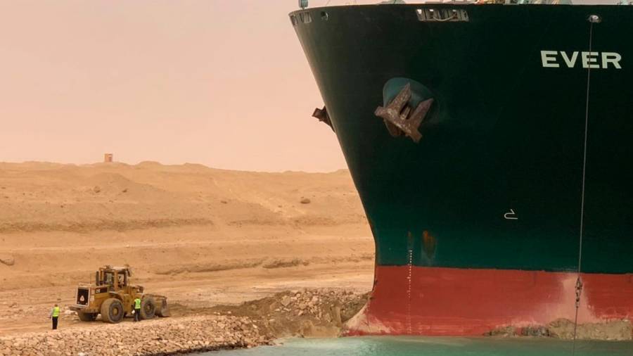 Una excavadora intenta liberar el extremo delantero del buque portacontenedores Ever Given, operado por Evergreen Marine, después de encallar en el extremo sur del Canal de Suez, bloqueando el tráfico de navegación en ambas direcciones. Europa Press 