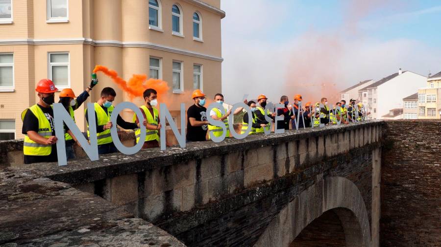 Miembros de la plantilla de Alcoa San Cibrao realizan un acto reivindicativo este viernes en la muralla romana de Lugo a favor de la venta de la planta de aluminio a GFG Alliance. FOTO: EFE/ Eliseo Trigo