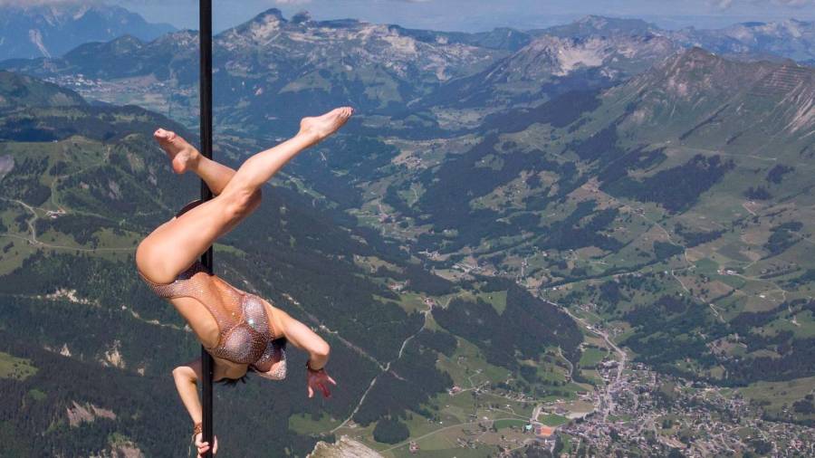 Sheila Nicolodi, acróbata italiana, realizando un baile sobre un poste en lo alto de los Alpes Suizos. (Autor, Laurent Gilleron. Fuente, EFE.)