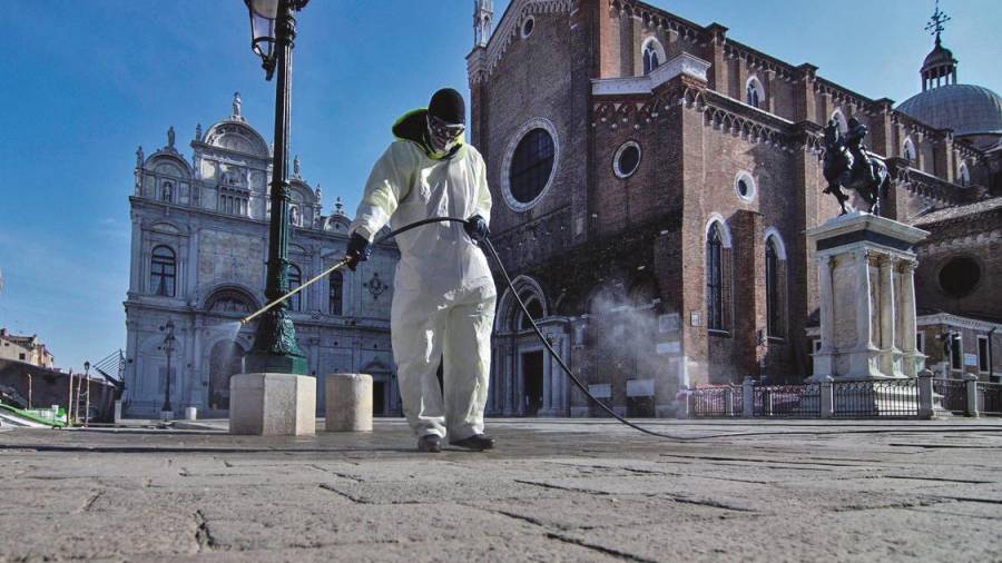 Un operario desinfecta la plaza de San Marcos, en Venecia.