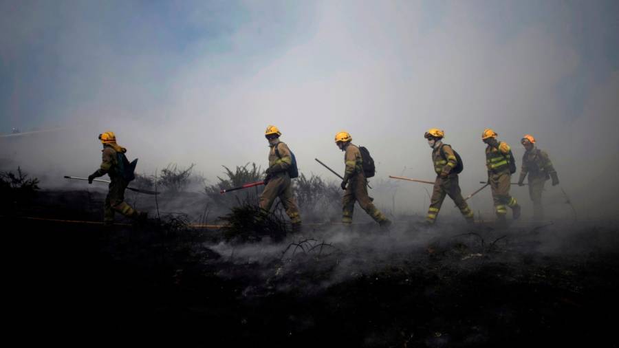 Miembros de una bigrada en San Pedro de Visma, donde ayer se registró otro incendio muy próximo a las casas del barrio de Os Rosais (A Coruña), ya extinguido. Foto: Cabalar
