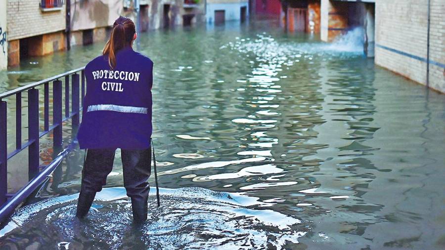 Una integrante de Protección Civil observa una calle inundada en Tudela. Foto: Iván Delgado/E.P.