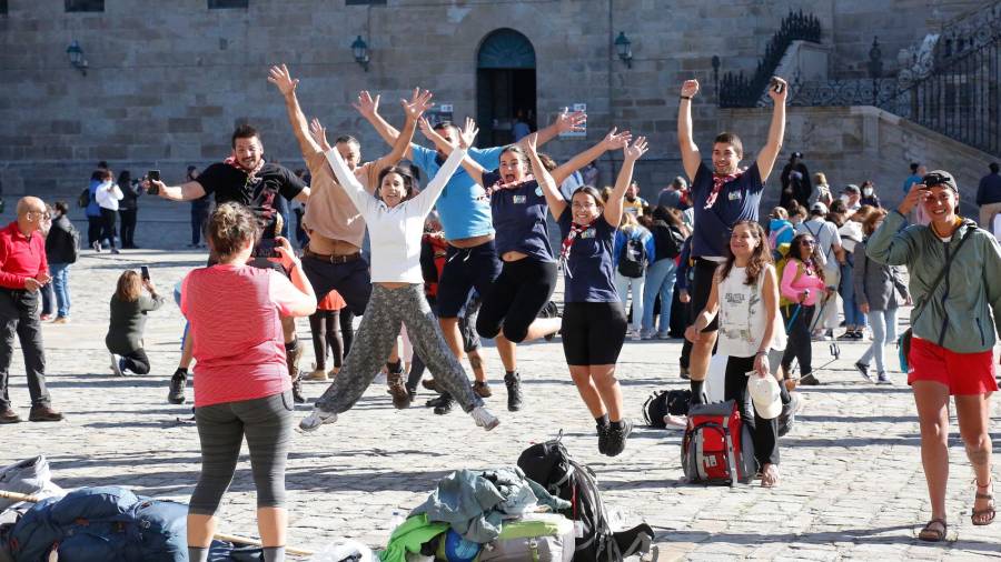 RUTA JACOBEA. Un grupo de peregrinos muestra su alegría en la praza do Obradoiro tras completar el Camino. Foto: A. Hernández