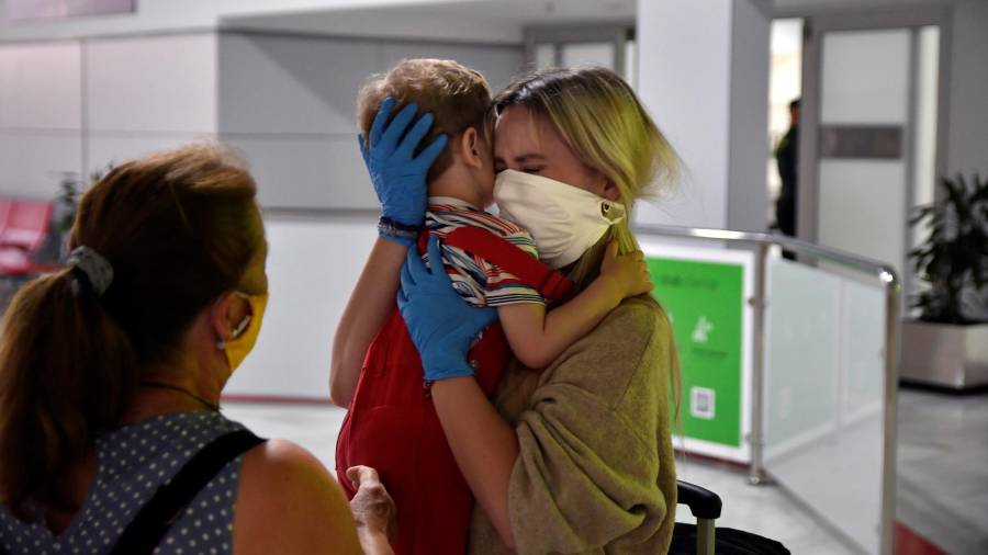 ALMERIA, 02/07/2020.- Una mujer abraza a un niño a su llegada ayer jueves en el primer vuelo internacional al aeropuerto de Almería tras la crisis de la COVID-19, procedente de Manchester (Reino Unido) y operado por la compañía irlandesa Ryanair. EFE/Carlos Barba