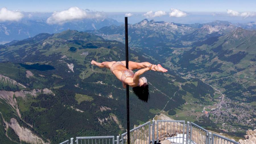 La acróbata italiana Sheila Nicolodi realizando un baile sobre un poste en los Alpes Suizos. (Autor, Laurent Gilleron. Fuente, EFE.)