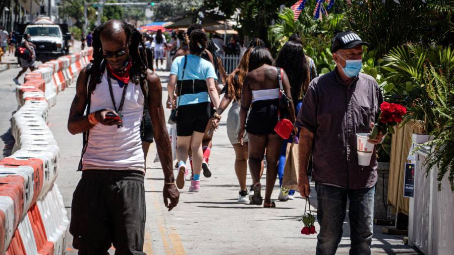 MIAMI BEACH (FL, EEUU), 03/07/2020.- Personas usando mascarilla tapabocas pasean antes del toque de queda este viernes en el paseo turístico de Ocean Drive en Miami Beach, Florida. EFE/Giorgio Viera