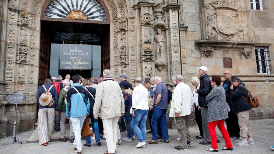Un grupo de turistas accede al Parador Nacional de la capital gallega, situado en pleno Obradoiro. Foto: Antonio Hernández