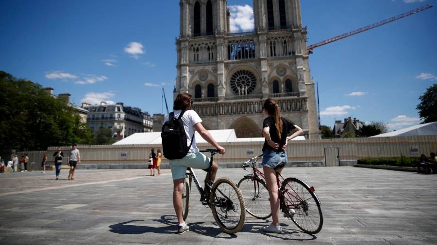 PARÍS. Dos ciclistas se paran delante de la Catedral de Notre Dame, este domingo, en París. EFE/EPA/YOAN VALAT