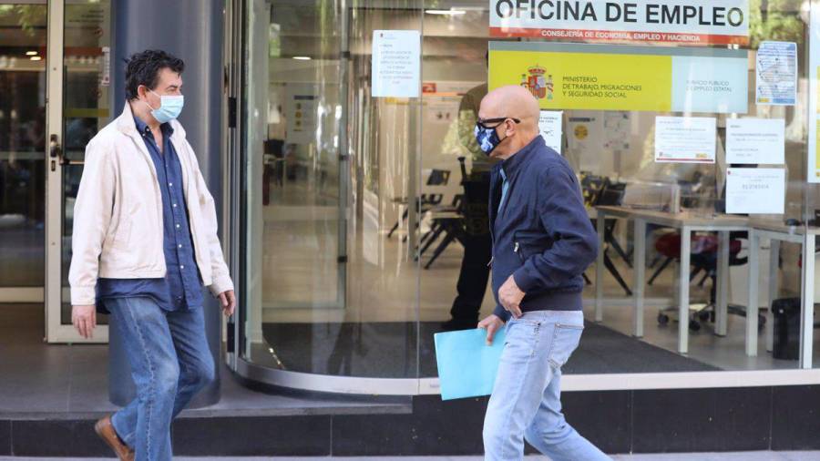 En la foto de archivo, un hombre con mascarilla pasa por una oficina de empleo de Madrid (España). MARTA FERNÁNDEZ/EUROPA PRESS