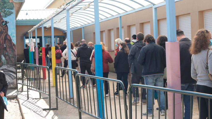 Decenas de personas hacen cola para votar en el Colegio Público La Navata. Foto: Marta Fernández Jara