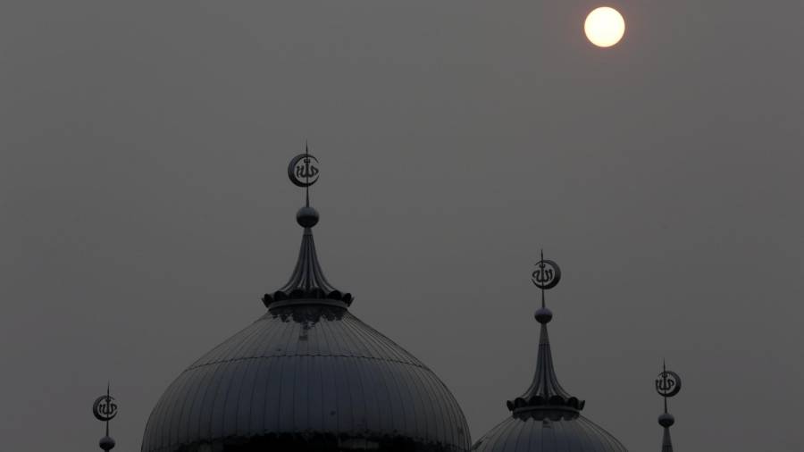 El sol aparece a través de la neblina gris sobre las cúpulas de la mezquita indonesa de la ciudad de Banda Aceh. (Autor, Hotli Simajuntak. Fuente, EFE)