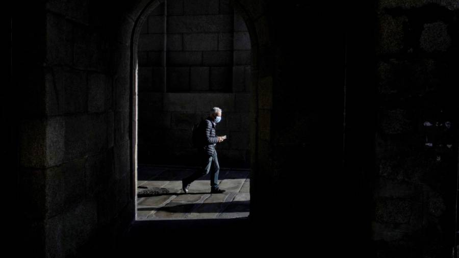 En la foto de archivo, un hombre con mascarilla camina por el centro de A Coruña. EFE/ Cabalar
