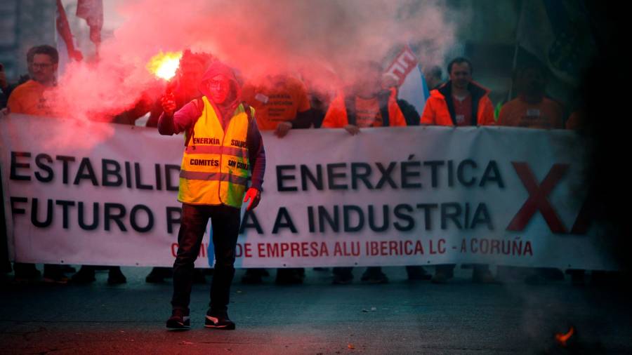 ÚLTIMA PROTESTA previa al estado de alarma de los trabajadores de Alu Ibérica A Coruña, con un hombre sosteniendo una bengala, el pasado 11 de marzo. También ardían entonces las barricadas. Foto: Efe/Cabalar