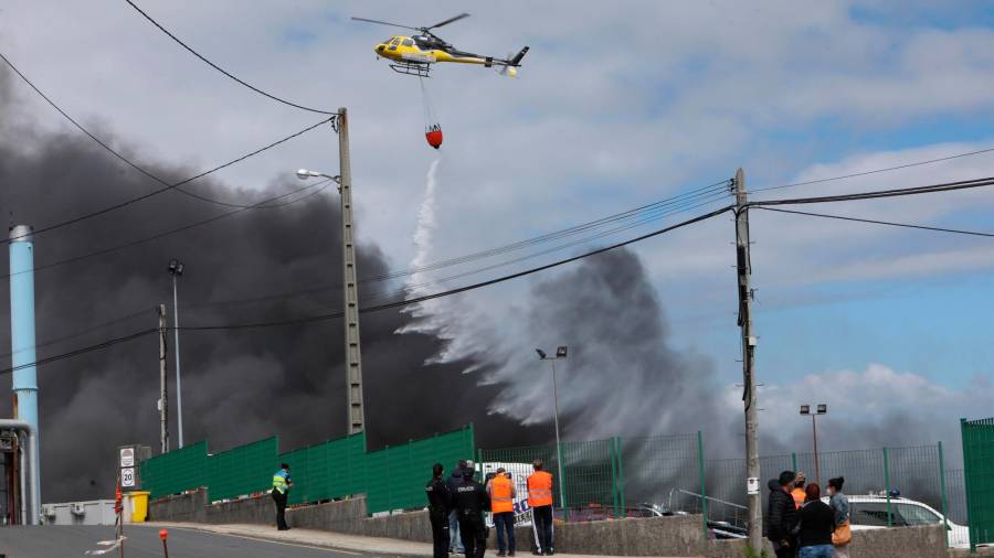 BOIRO, 08/05/2021.- Un helicóptero trabaja en las labores de extinción del incendio industrial de origen desconocido originado en la planta que la conservera Jealsa tiene en Boiro (A Coruña). EFE/Xoán rey