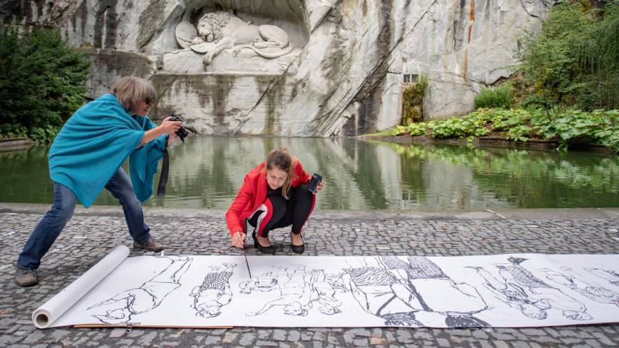 La artista Olga Georgieva pintando delante del famoso monumento de Lucerna. Foto: EFE