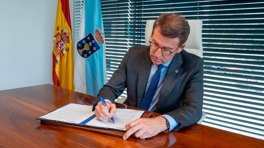 El presidente de la Xunta y candidato a liderar el PP, Alberto Núñez Feijóo, firma su dimisión como presidente de los populares gallegos
