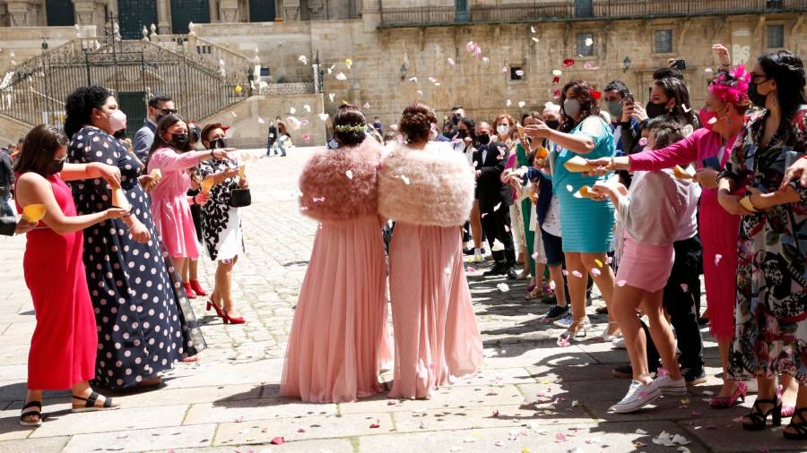 BODA Dos mujeres caminan por el Obradoiro ante la mirada de los invitados tras casarse en Raxoi. Foto: A. H.