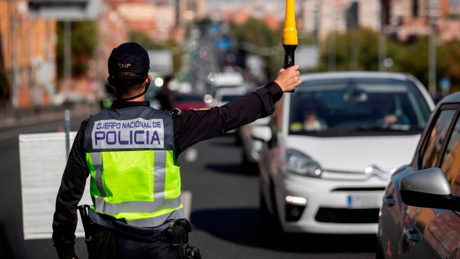 Un policía controla las medidas restrictivas de movilidad ayer a mediodía en la Nacional VI. Foto: Efe