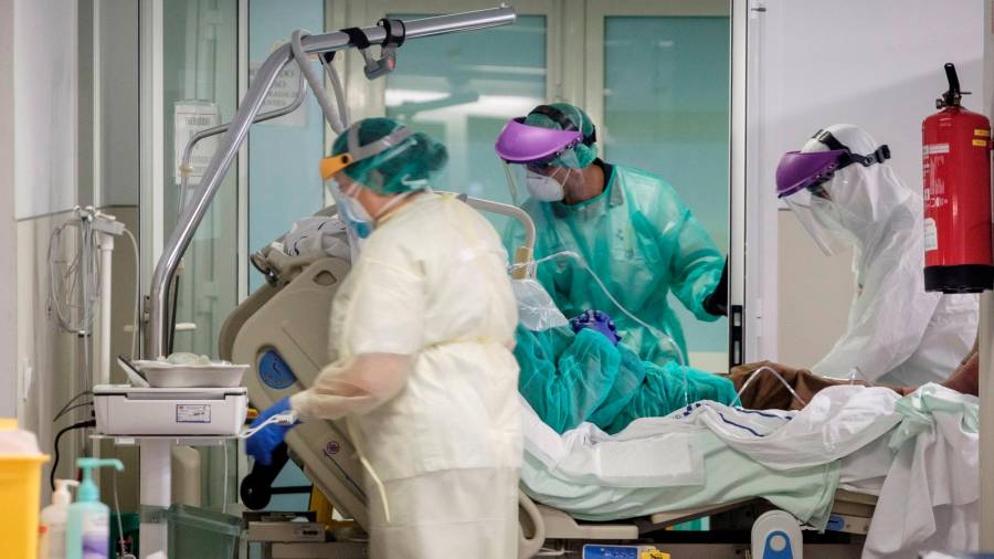 Tres profesionais sanitariosprestan atención a un doente de covid-19. Foto: Ángel Medina