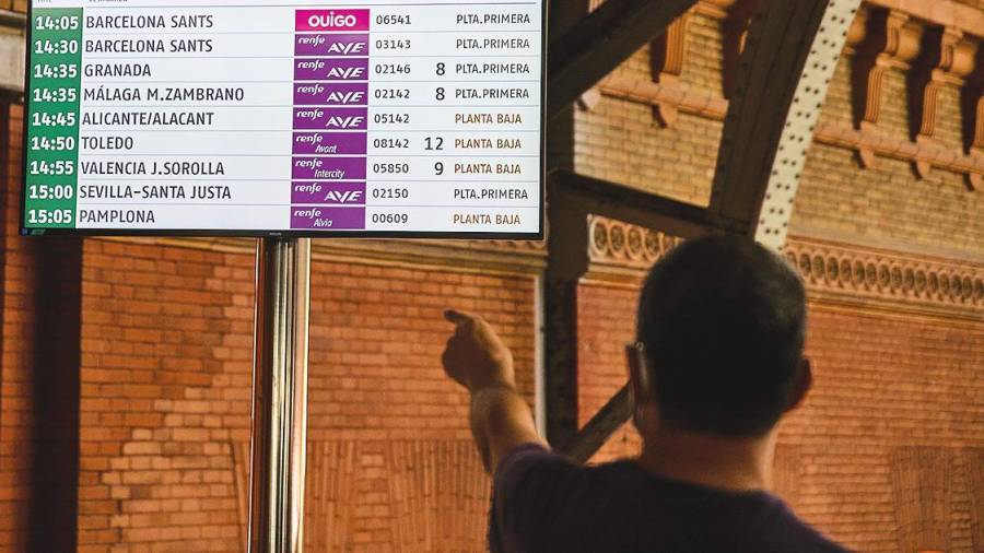 Un hombre observa la información del panel de llegadas y salidas en la Setación de Atocha de Madrid. Foto: Jesús Hellín/E.P.
