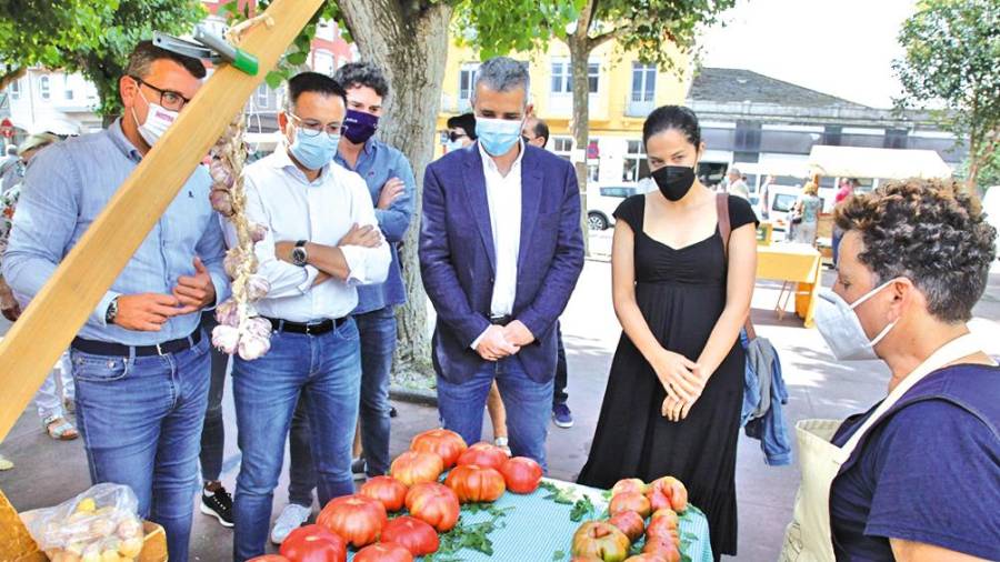 El conselleiro José González, segundo desde la izquierda, este domingo en su visita al mercado de Ribadeo (Lugo).