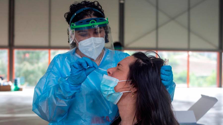 Una trabajadora sanitaria realiza una prueba PCR a una mujer, durante el cribado realizado este lunes a la población de Sobradelo. (Foto: EFE/Brais Lorenzo)