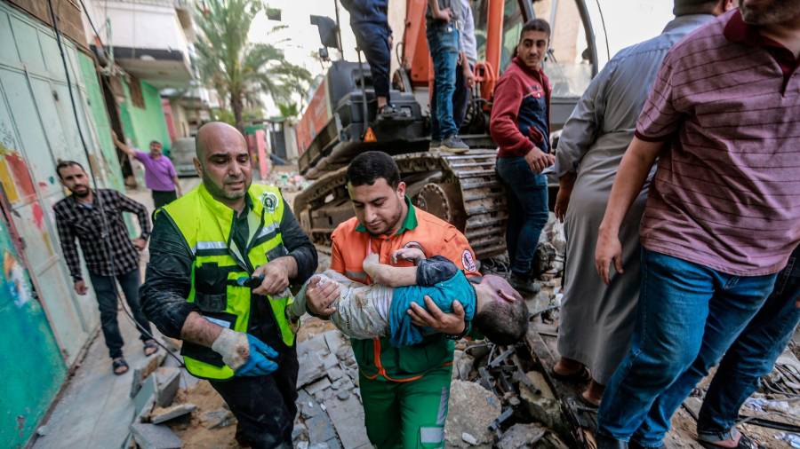 16 de maio de 2021, Territorios palestinos, cidade de Gaza: os paramédicos palestinos desenterran o corpo dun neno morto atopado nos cascallos dunha casa derrubada tras un ataque aéreo israelí, no medio do intenso estalido da violencia israelí-palestina. Foto: Mohammed Talatene / dpa