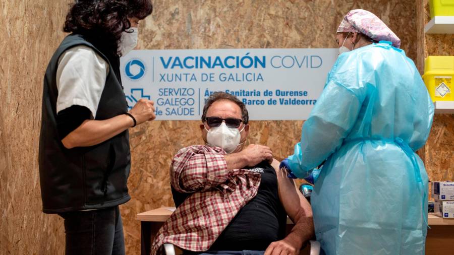 OURENSE, 07/04/2021.- Un hombre recibe la vacuna de AstraZeneca durante la campaña de vacunación masiva que se lleva a cabo estos días en el recinto ferial Expourense, este miércoles en Ourense. EFE/ Brais Lorenzo