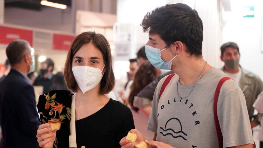 Dos jóvenes aprovechan su asistencia al certamen para degustar la bica de Vimianzo