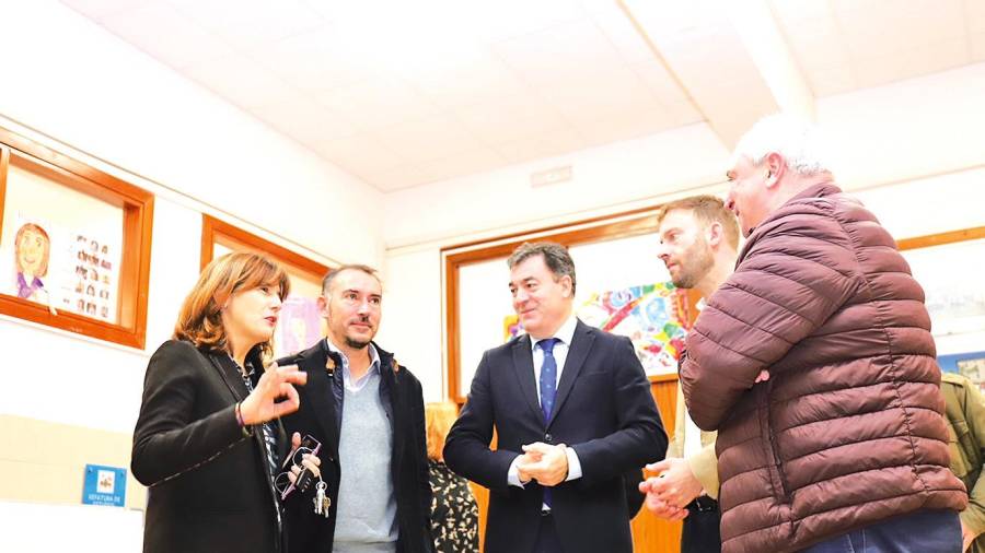 Rodríguez, en el centro, junto al alcalde, a su derecha, y el delegado territorial, a su izquierda, con responsables del CEIP Flavia. Foto: Sangiao
