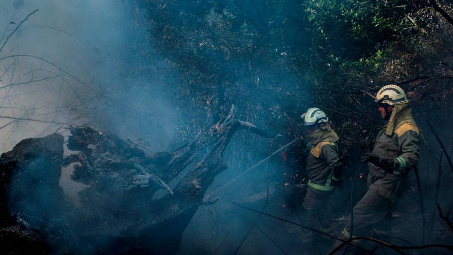 GRAF3689. PARADA DE SIL (OURENSE), 12/09/2020.- Dos bomberos forestales realizan labores de extinción este sábado en un incendio forestal en Parada de Sil (Ourense), que se suma a los de Vilar Barrio (Ourense) y Quiroga (Lugo). EFE/ Brais Lorenzo