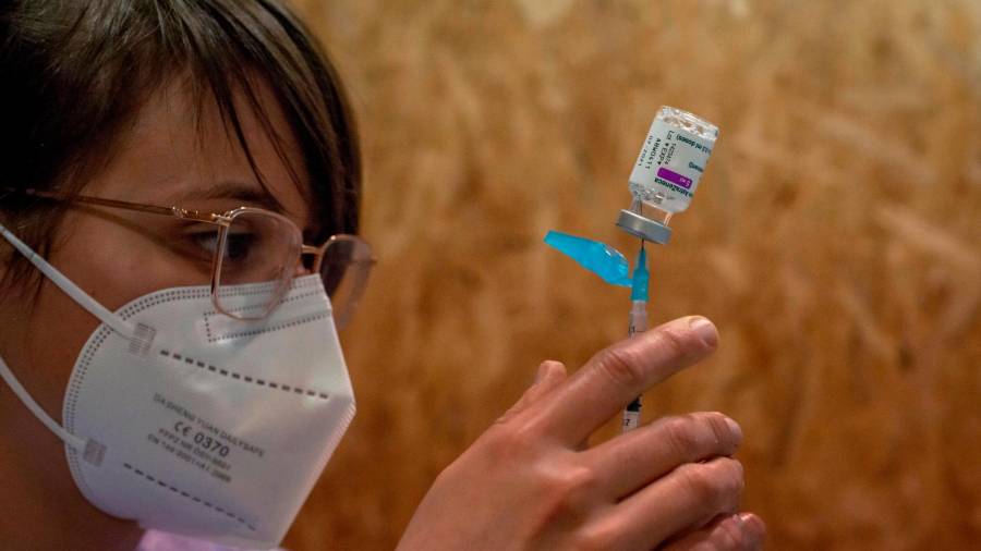 OURENSE, 07/04/2021.- Una empleada sanitaria prepara una dosis de la vacuna de AstraZeneca durante la campaña de vacunación masiva que se lleva a cabo estos días en el recinto ferial Expourense, este miércoles en Ourense. EFE/ Brais Lorenzo