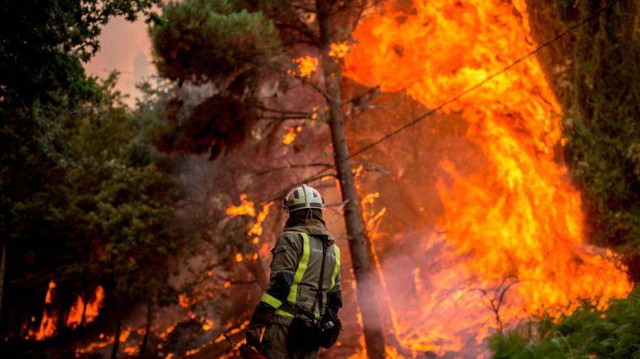 GRAF9823. TOÉN (OURENSE), 07/08/2020.- Un bombero realiza labores de extinción en el incendio forestal que permanece activo en el municipio orensano de Toén. EFE/Brais Lorenzo