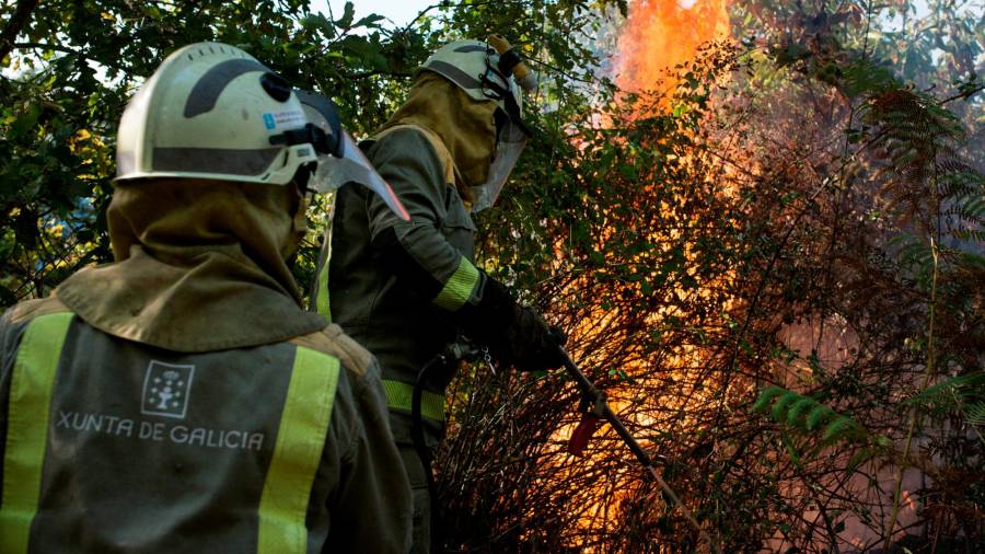 GRAF3689. PARADA DE SIL (OURENSE), 12/09/2020.- Dos bomberos forestales realizan labores de extinción este sábado en un incendio forestal en Parada de Sil (Ourense), que se suma a los de Vilar Barrio (Ourense) y Quiroga (Lugo). EFE/ Brais Lorenzo