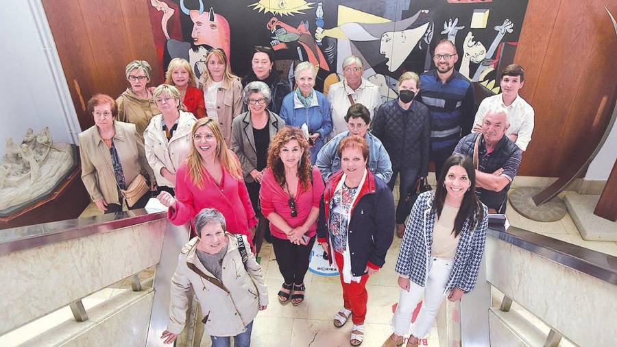 exposición. Na segunda fila, as edís Ana Barreiro, esquerda, e María Sampedro, dereita, con algúns dos autores da mostra ante o Guernica que fixeron de xeito colectivo. Foto: C. R.