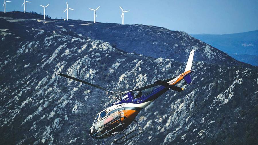 boiro. Un helicóptero realiza labores de extinción para tratar de apagar el incendio del Barbanza. Foto: Óscar Corral / Efe