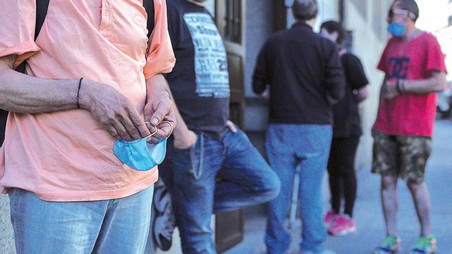 Personas haciendo cola para entrar en el comedor social de Cáritas en Ourense. Foto: B.L / Archivo.
