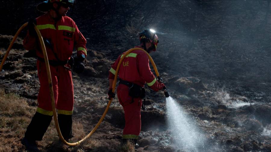 CUALEDRO (OURENSE), 15/09/2020.- Un efectivo de la Unidad Militar de Emergencia refresca el perímetro del incendio forestal de Cualedro (Ourense). EFE/Brais Lorenzo
