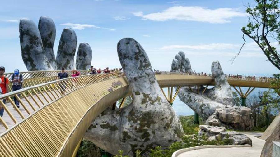 Golden Bridge. Una obra majestuosa en la que dos manos gigantes sostienen una pasarela dorada de 150 metros a 1400 metros sobre el nivel del mar. Ubicada en Vietnam, más concretamente en las montañas sobre Da Nang. (Fuente, www.hola.com. Imagen, www.gettyimages.es)
