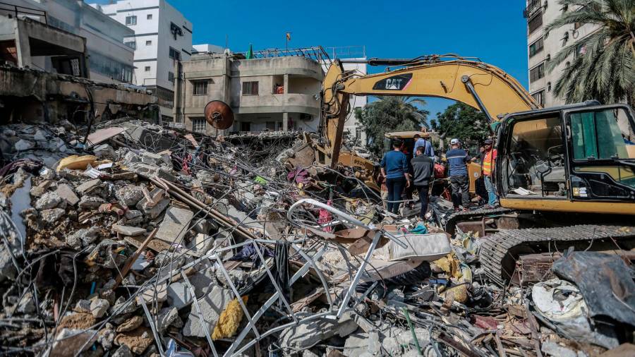 16 de maio de 2021, Territorios palestinos, cidade de Gaza: os paramédicos palestinos desenterran o corpo dunha persoa morta atopada nos cascallos dunha casa derrubada tras un ataque aéreo israelí, no medio do intenso estalido da violencia israelí-palestina. Foto: Mohammed Talatene / dpa